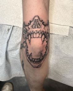 a man's leg with a tattoo on it that has a skull and teeth