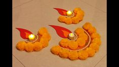 three small yellow and red decorations with candles in them on the floor next to each other