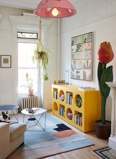 a living room filled with furniture and a large flower pot on top of a table