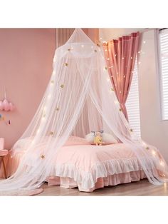 a bed with a white canopy and pink curtains