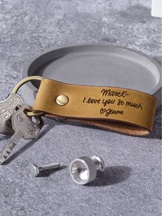 a couple of keys sitting on top of a metal plate next to a keychain