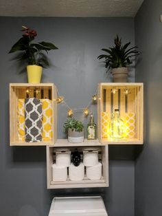 the bathroom is decorated with yellow and white accessories, such as toilet paper rolls and plants