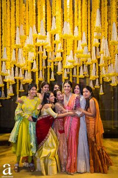 a group of women standing next to each other in front of a chandelier