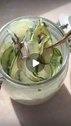 a glass jar filled with cucumbers and onions