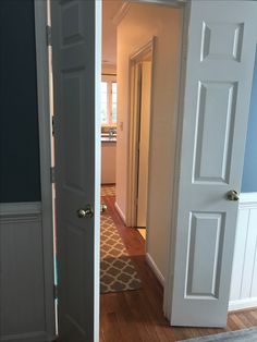 an open door leading to another room with hardwood floors and white trim on the walls