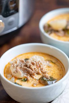 two bowls of soup with meat and vegetables in front of an instant pressure cooker