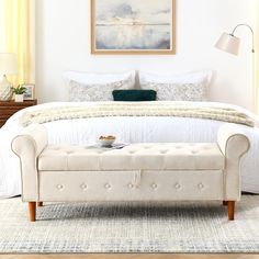 a white bed sitting in a bedroom next to a window