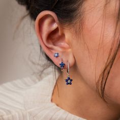 B L U E ∙ F L O W E R ∙ E A R R I N G ∙ S E T Elevate any ensemble with our Blue Flower Earring Set, a delightful trio consisting of a stud and two hoops, offering versatility to suit your style. With deep blue gemstones exuding elegance and floral motifs adding a touch of youthful charm, this set makes for the perfect anniversary gift, celebrating love with every wear ♡  * Material: High Quality Solid 925 Sterling Silver  * Finish: 18K Gold ∙ Sterling Silver * Featuring a Set of 3 CZ Gemstone S Silver Anniversary Gifts, Flower Earring, Silver Anniversary, Gemstone Stud Earrings, Flower Stud Earrings, Flower Stud, Funky Jewelry, Jewelry Lookbook, Gemstone Studs