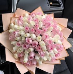 a bouquet of pink and white roses is in the passenger seat