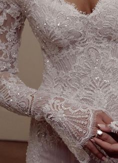 a close up of a person wearing a wedding dress and holding something in their hand