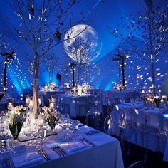 a table set up with white linens and silverware for an elegant wedding reception