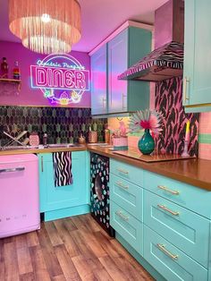 a brightly colored kitchen with pink, blue and green accents on the cabinets is pictured in this image