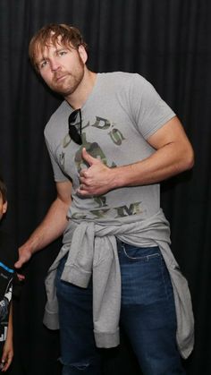 a man standing next to a little boy in front of a black background holding a camera