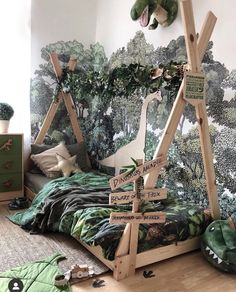 a child's bedroom decorated in green and white with trees on the wall behind it