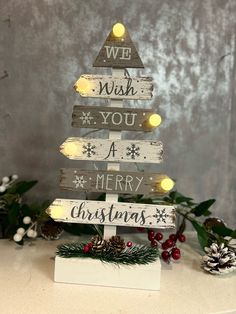 a christmas tree made out of wood with lights on it and the words we wish you a merry christmas