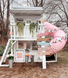 a pink slide is in the middle of a yard with lots of plants on it