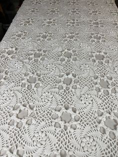 the tablecloth is white with crochet on it and has an intricate design