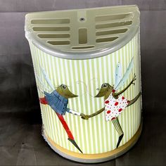 a trash can with an image of two people holding hands and flying birds on it