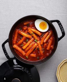 carrots and an egg are in a pan on the table next to some pancakes