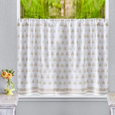 a window with a white curtain and some flowers