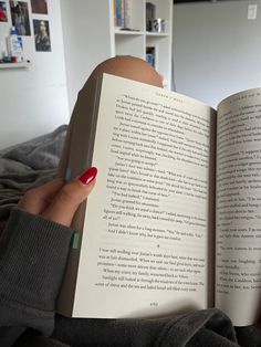 a person is holding an open book in their hand