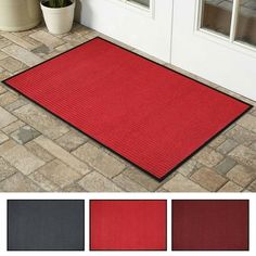 a red door mat sitting on top of a brick floor next to a potted plant