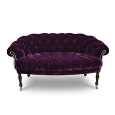 a purple velvet couch with white piping on the arms and legs, sitting against a white background