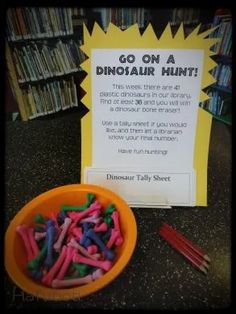 a bowl full of colored pencils next to a sign that says go on a dinosaur hunt