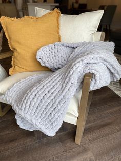 a chair with a blanket and pillows on it