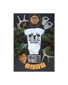 a baby's bodysuit surrounded by antlers, pine cones and other items