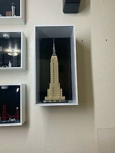 three legos are placed on the wall in different shapes and sizes, including an empire building