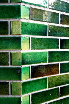 a green brick wall that is very close to the ground