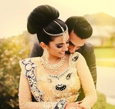 a man and woman dressed in wedding attire hugging each other with their foreheads touching