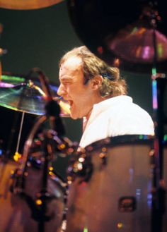 a man that is sitting in front of a drum set