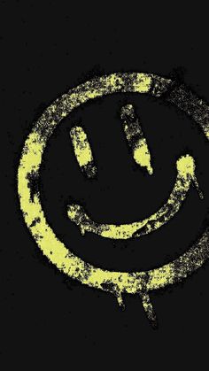 a smiley face drawn in the middle of a black background with yellow paint on it