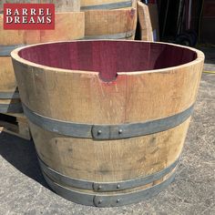 two wooden barrels sitting next to each other on top of a cement floor with the barrel dreams logo above them