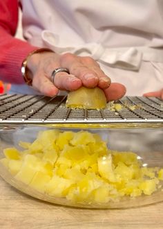 a person is peeling potatoes on a metal rack