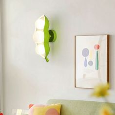 a living room with a green couch and colorful pillows on the wall next to it