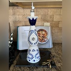 a blue and white vase sitting on top of a table next to an open book