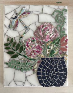 a mosaic with flowers and leaves on it