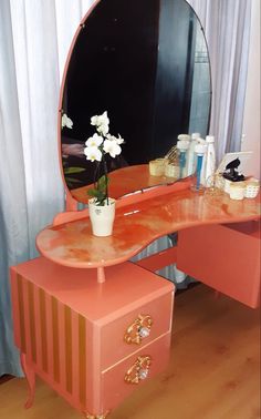 an orange vanity with flowers on it in front of a mirror