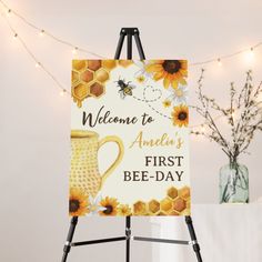 an easel with a sign that says welcome to america's first bee - day