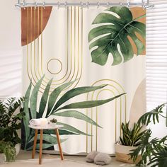 a shower curtain with tropical leaves and gold lines on the wall next to a chair