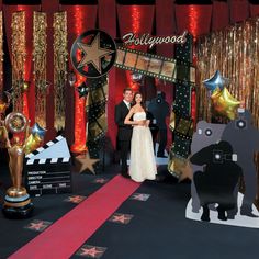 a newly married couple standing in front of an entrance to the hollywood movie set at their wedding reception