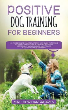 a woman petting a dog in the grass with her hand up to it's mouth