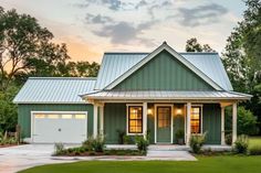 a green house with two garages in the front yard