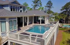 an aerial view of a house with a swimming pool and deck area in the foreground