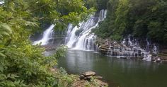 a large waterfall in the middle of a forest