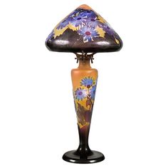 a lamp that is sitting on top of a wooden stand with flowers painted on it