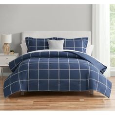 a bed with blue and white plaid comforter